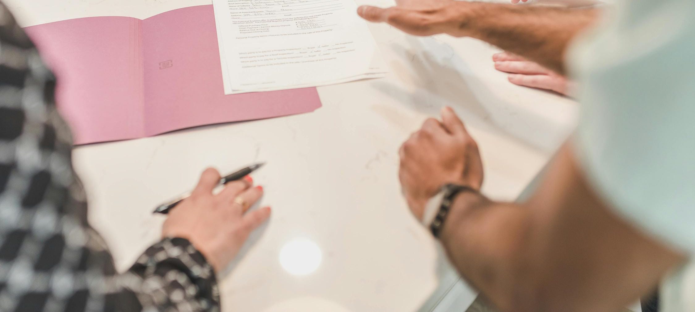 Close-up of people reviewing block management paperwork, symbolising effective communication.