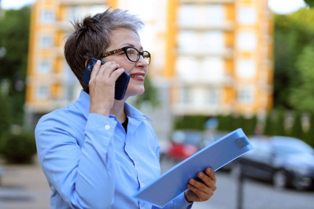 Person standing outside a modern block of flats, representing residential property management