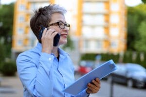 Person standing outside a modern block of flats, representing residential property management