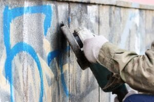 Graffiti being cleaned from a wall, representing antisocial behaviour in residential blocks.